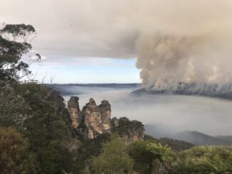 The iconic rock formation, Three Sisters, overlook the bushfires at Mount Solitary at Blue Mountains National Park.